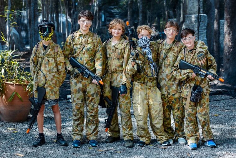 A kids' party group in camo gear with gel blasters