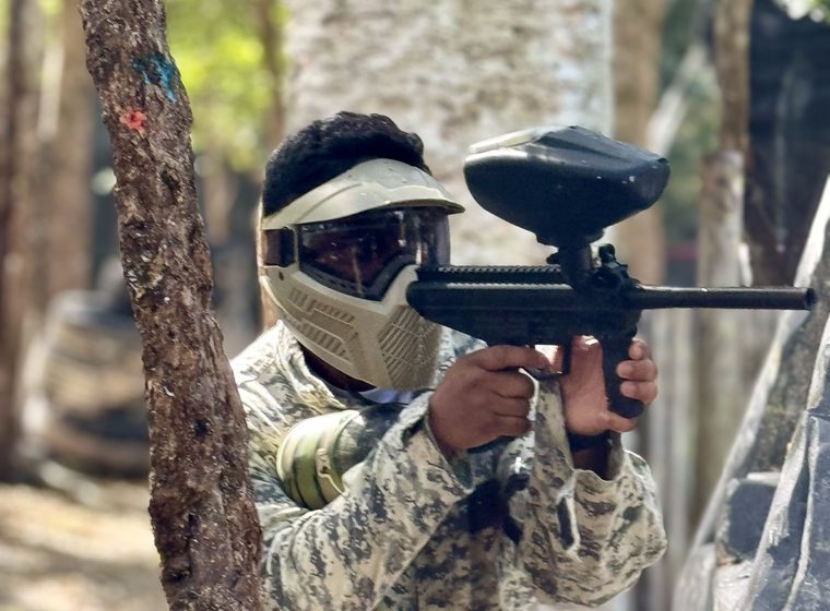 A player sighting down the marker in full protective gear